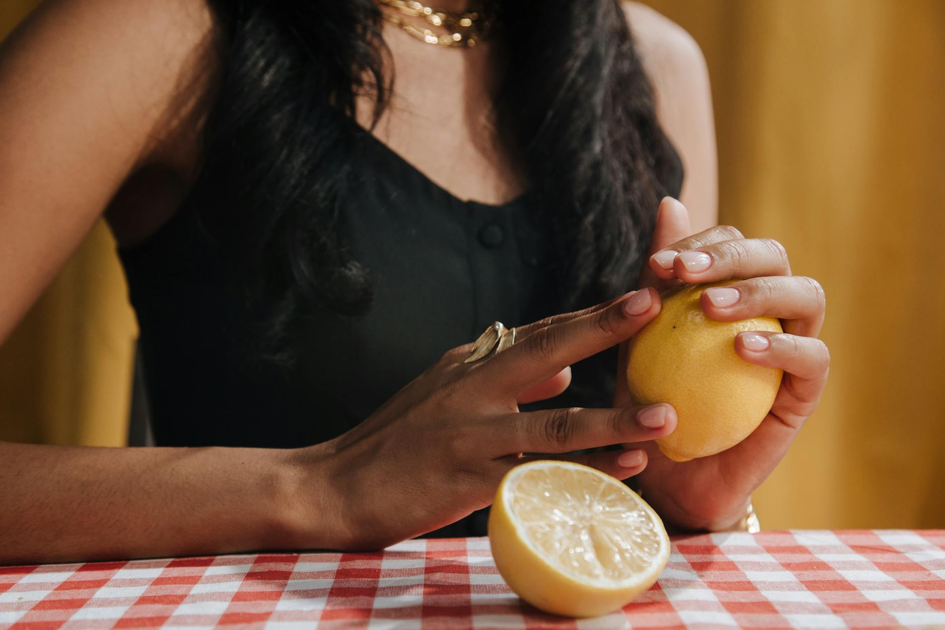 Close-up of a woman holding a fresh lemon, symbolizing the Lem vibrator and renewed sensuality