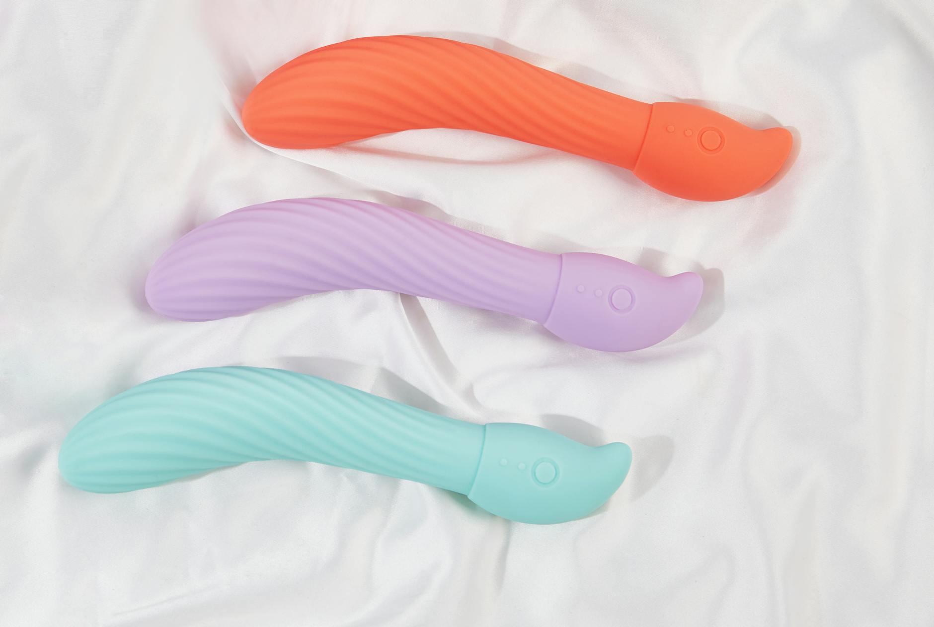 Mão segurando vibrador de limão contra fundo roxo minimalista, mostrando design e textura do produto