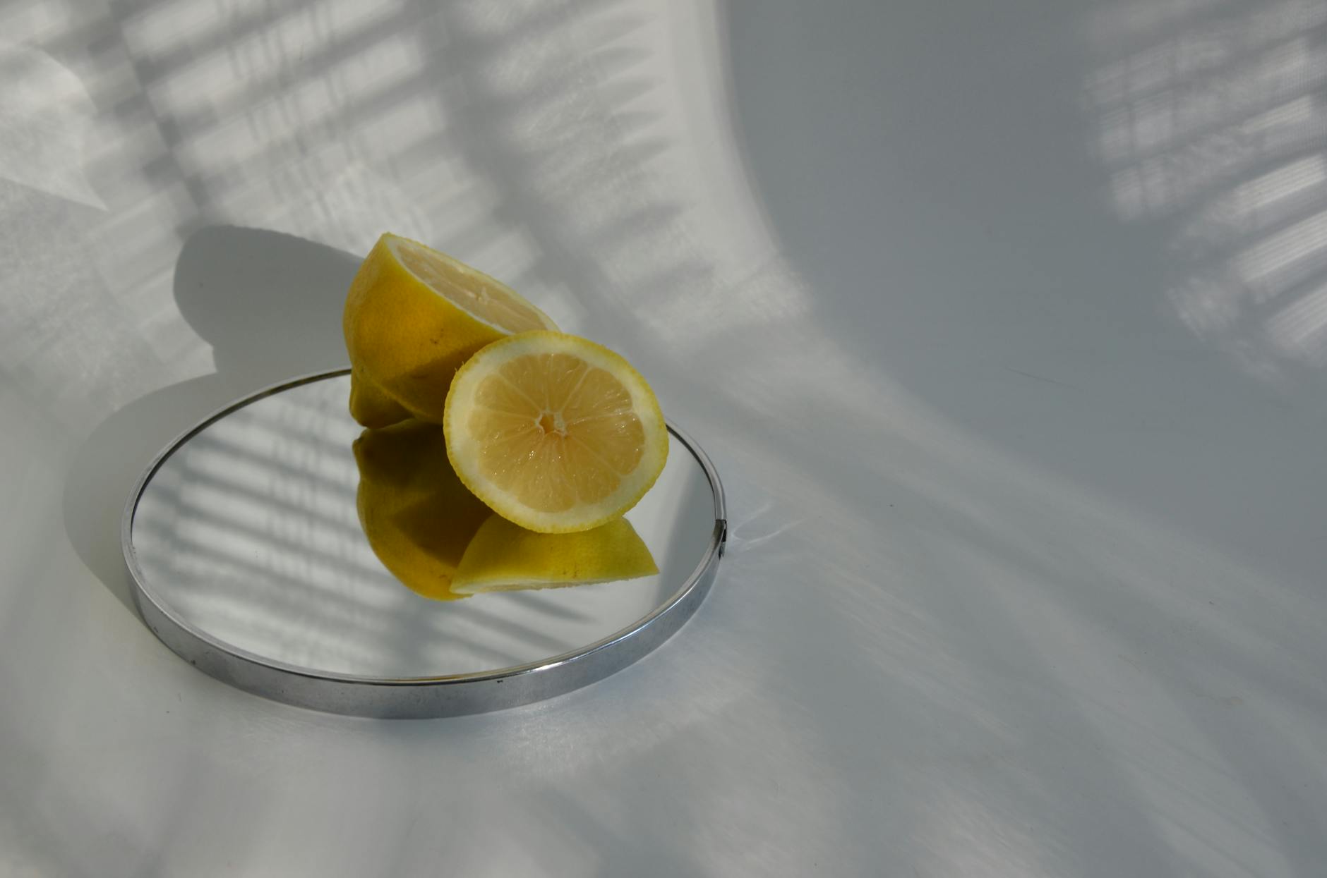 Hand holding a lemon on a soft pink background, showcasing smooth and sensory-friendly textures
