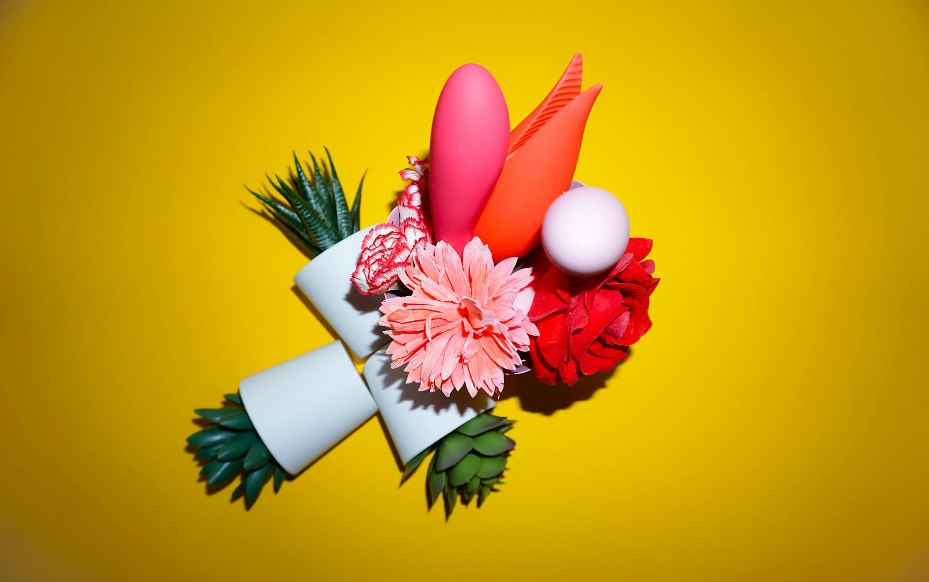 Vibrant arrangement of intimate wellness items and flowers on a bright background