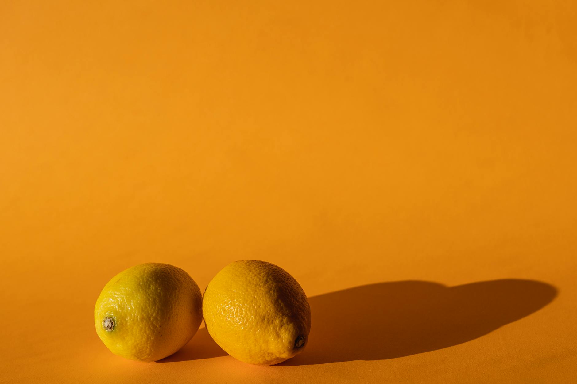 Bright ripe lemons with pedicels on a pastel background representing the Lemon Clitoral Vibrator